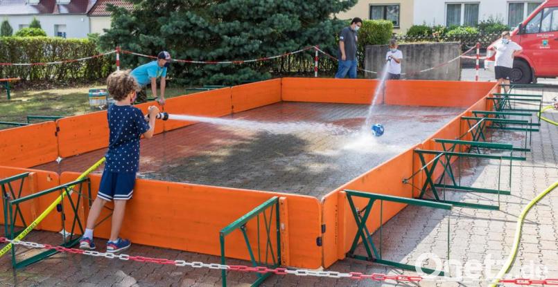 Die Kinder mussten sich ganz schön ins Zeug legen und eine gehörige Portion Zielsicherheit und Kondition aufbringen beim Versuch, den Ball mit einem Wasserstrahl aus einem C-Schlauch ins gegnerische Tor zu spritzen, Bild: u