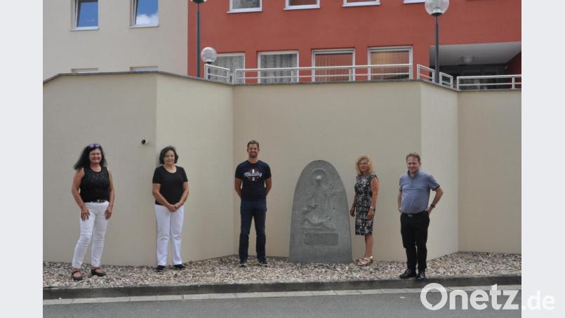 Der heimische Granitstein zeigt ein Werk der Barmherzigkeit. Ein Steinmetz hat diese Darstellung im frühen 19. Jahrhundert akribisch aus dem Stein herausgearbeitet. Christine Schmidt (Zweite von rechts) vermachte das Kunstwerk nun der katholischen Pfarrgemeinde. Die Aufstellung war ein Gemeinschaftswerk von Schmidt und Bauunternehmer Michael Töppel (Dritter von links), der seine Fundamentarbeiten ebenfalls kostenlos einbrachte. Die Vertreterinnen des Walter-Siegert-Caritasheims Karin Witt und Johanna Bodensteiner (von links) waren ebenfalls angetan von diesen Spenden. Bild: dob