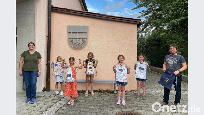 Stolz sind die Kinder auf ihren selbstgenähten Turnbeutel. Bild: nza