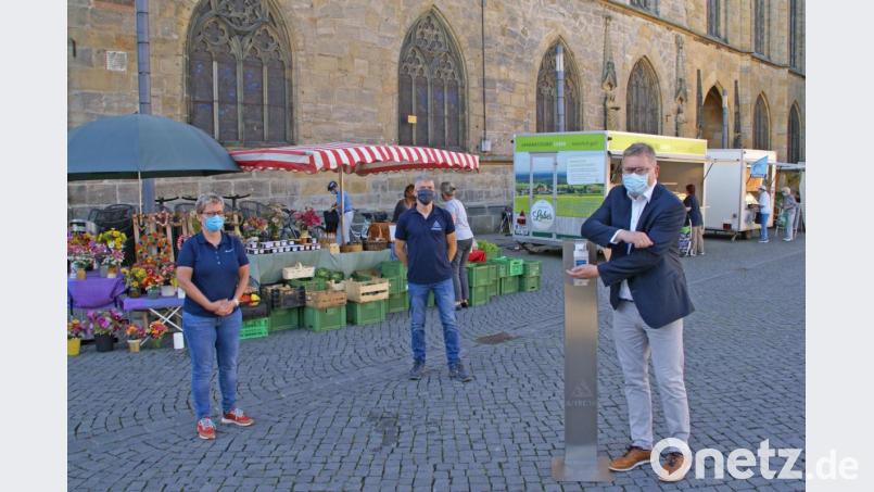 Oberbürgermeister Michael Cerny geht mit gutem Beispiel voran: Er nutzt mit Amtsleiterin Elisabeth Keck (links) und Lothar Thumbeck (Mitte) vom Amt für Ordnung und Umwelt den Desinfektionsspender auf dem Amberger Marktplatz. Bild: Ina Bogner, Stadt Amberg/exb