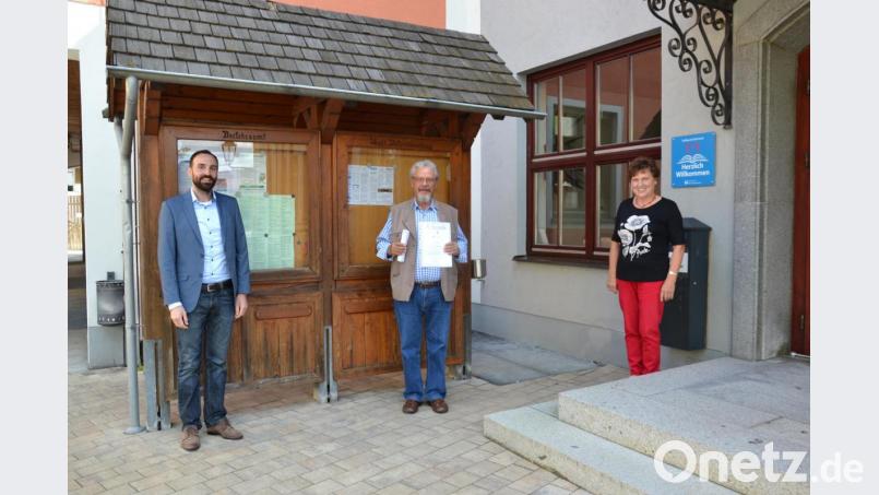 Bürgermeister Armin Bulenda (links) ehrt Peter Bosse (Mitte) für den 50. Aufenthalt in Moosbach. Auch Gastgeberin Erna Enslein gratuliert. Bild: gi