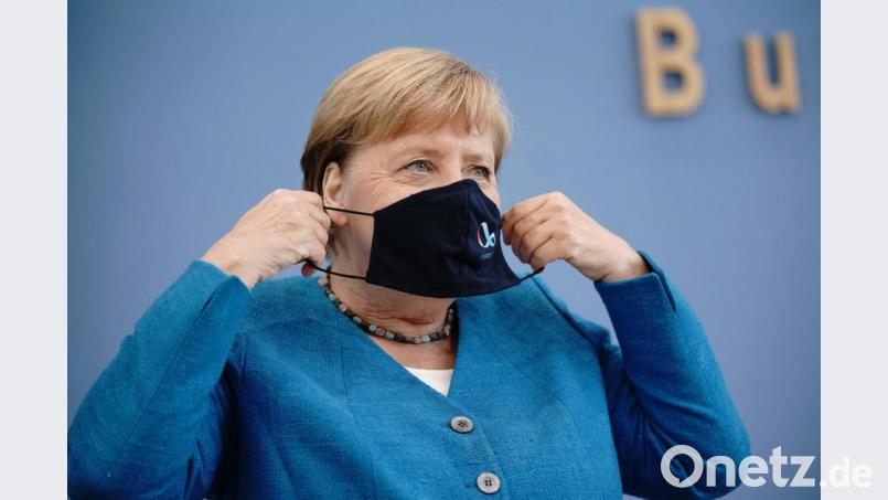 Bundeskanzlerin Angela Merkel (CDU) setzt in der Bundespressekonferenz nach ihrer traditionellen Sommer-Pressekonferenz zu aktuellen innen- und außenpolitischen Themen ihre Maske auf. Bild: Michael Kappeler/dpa