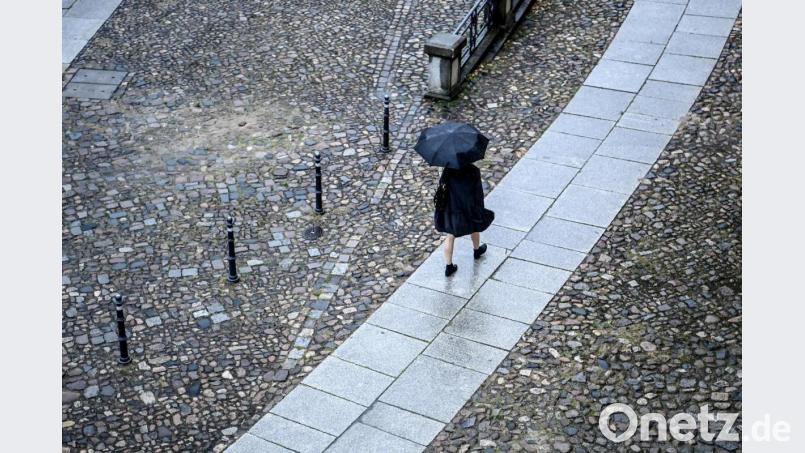 Eine Frau geht bei Regen eine Straße entlang. Foto: Britta Pedersen/dpa-Zentralbild/dpa/Symbolbild Bild: Britta Pedersen