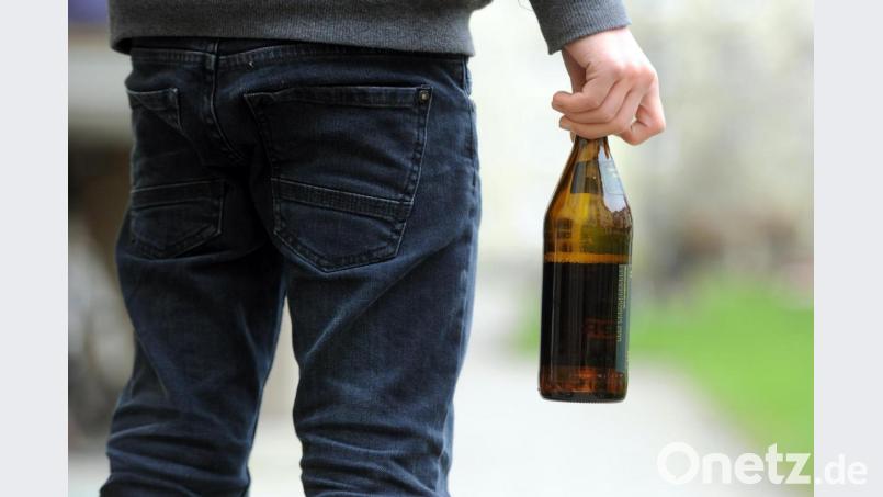 Ein Jugendlicher hält eine geöffnete Bierflasche in der Hand. Symbolbild: Tobias Hase/dpa