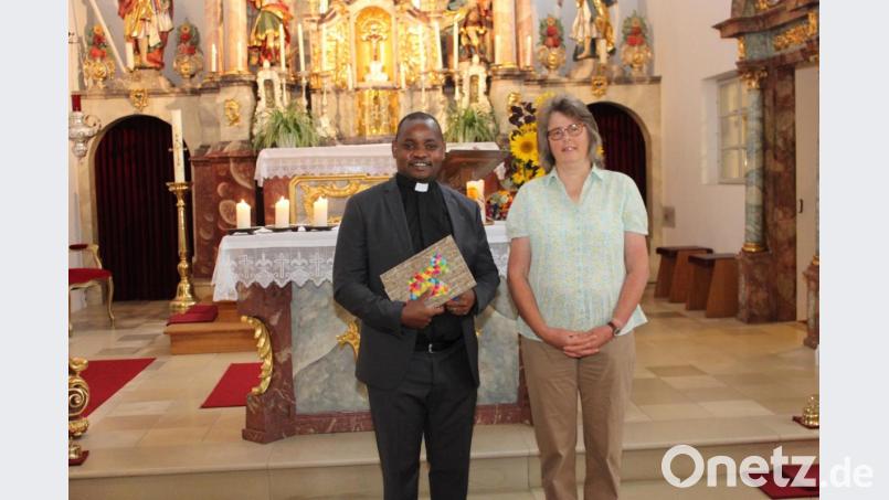 Pfarrgemeinderats-Sprecherin Gudrun Fischer überreicht Pfarrer Peter Lungu zum Abschied ein Fotoalbum mit Aufnahmen aus dem Pfarreileben und einem Büchergutschein von den Kirchenverwaltungen Utzenhofen, Albertshofen, Ransbach und Umelsdorf. Bild: aun