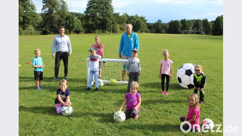 Bild zeigt die fußballbegeisterten Kinder beim Ferienprogramm der DJK zusammen mit Trainer Robert Söllner (hi.v.rer.) und Bürgermeister Wolfgang Söllner auf dem Sportplatz der DJK Ebnath. Bild: soj