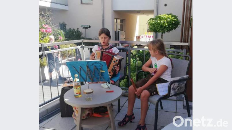 Auf Initiative von Tagespflegeleiterin Birgit Seidl feiern die Tagespflegegäste gemeinsam mit Bewohnern des Hauses Conrad ein Grillfest. Für das i-Tüpfelchen sorgen mit beschwingten Musikstücken die neunjährige Hannah mit ihrer Ziehharmonika und die sechsjährige Lotta auf ihrer Blockflöte. Bild: u