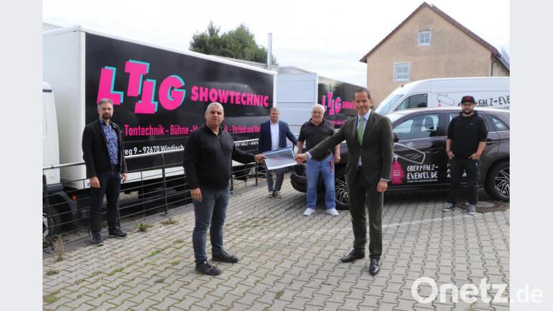 Tobias Grünes (zweiter von links) übergibt Politiker Albert Rupprecht eine Mappe mit den wichtigsten Infos, wo der Schuh in der Eventbranche drückt. Bild: vlu