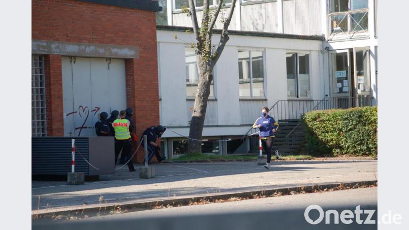 Die Beamten nähern sich der Tür des OTH-Gebäudes. Derweil flüchtet ein „Opfer“, gespielt von einem Praktikanten, aus dem Haus. Bild: gib