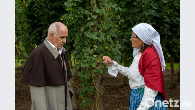 Hier agieren Alfons Wanninger als Amtsarzt und Bruni Lommer als Bäuerin. Die Kulisse lieferte der lllschwanger Hopfengarten kurz vor der Ernte. Bild: Sasan Akbari