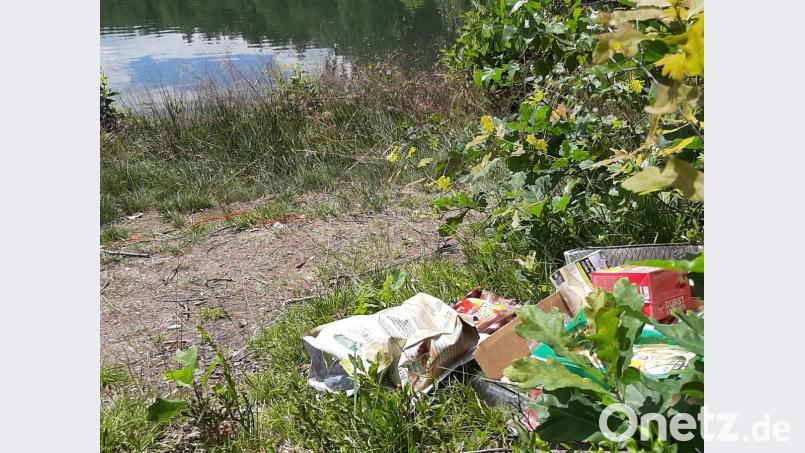 Ein Einweg-Grill, Schachteln, herumliegende Bierflaschen und Plastik: Der Müll am See deutet auf eine Party hin. Bild: ubb