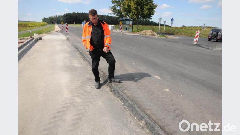 Rund 14 Zentimeter ist die neue B 14 an manchen Stellen nun höher, zeigt Baudirektor Stefan Noll an dieser Einmündung. Bild: Joachim Gebhardt