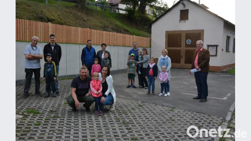 Nahezu das ganze Dorf steht hinter der teilweisen Neugestaltung des Dorfmittelpunkts in Königshütte. Am Hang beim Feuerwehrhaus wurde eine neue Betonstützmauer gebaut, darauf wurde ein Zaun aus Lärchenholz gesetzt. Die Dorfbewohner und Bürgermeister Johann Burger (rechts) freuen sich über die Maßnahmen. Bild: jr