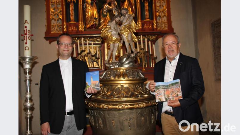 Stadtpfarrer Thomas Helm (links) und Kirchenpfleger Josef Beer sind begeistert vom neuen Kirchenführer für die Basilika St. Martin. Bild: ads