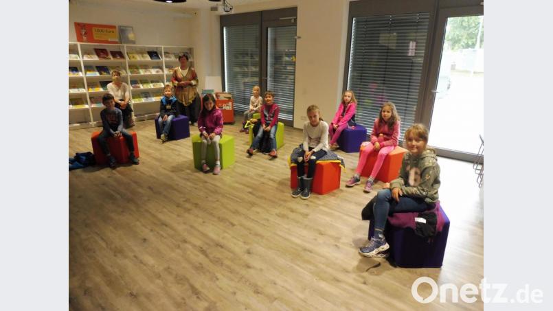 Sehr aufmerksam waren die Kinder bei der Sache, als Margarete Mildner (hinten, stehend) im Buch-Haus Märchen erzählte. Bild: ibj
