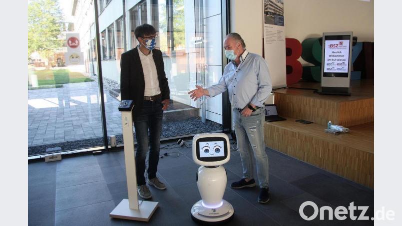 Rainer E. Becker, von der Firma ShowBotiXX, erklärt Schulleiter Thomas Metzler die Funktionen des Roboters „Jamie“, der Steuerungs-App und der dazugehörigen Thermo-Stele. Bild: wro