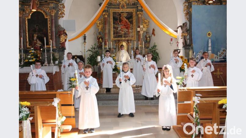 Zwölf Mädchen und Jungen treten am Sonntag erstmals an den Tisch des Herrn. Mit ihnen freut sich Pfarrer Julius Johnrose. Bild: pi
