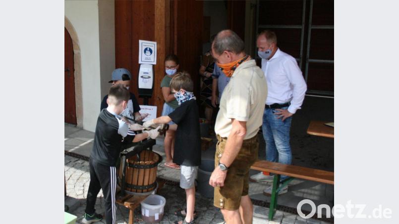 Znd wieder war Muskelkraft gefragt. Aber der Lohn des Schweißes läuft schon in den Eimer. Auch erster Bürgermeister Marcus Eichenmüller (re) war gespannt, wieviel Saft heraus kommt. Bild: nag