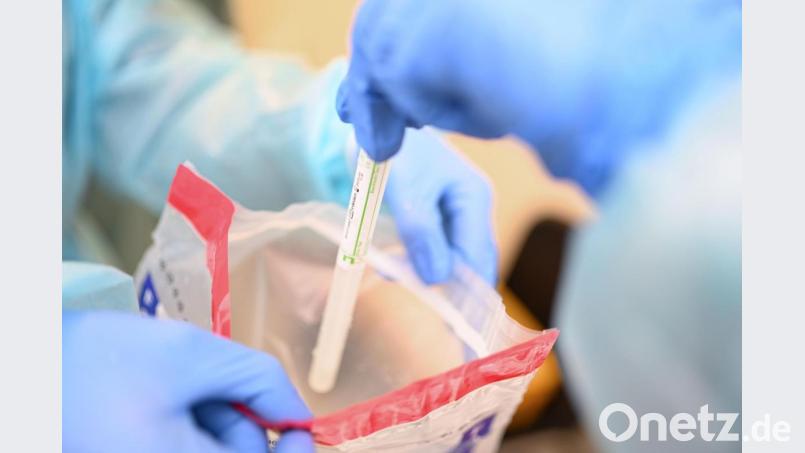 Eine Ärztin gibt einen Abstrichstäbchen im Plastikröhrchen in einen Plastikbeutel, nachdem sie einem Patienten einen Abstrich aus dem Rachen entnommen hat. Bild: Felix Kästle/dpa