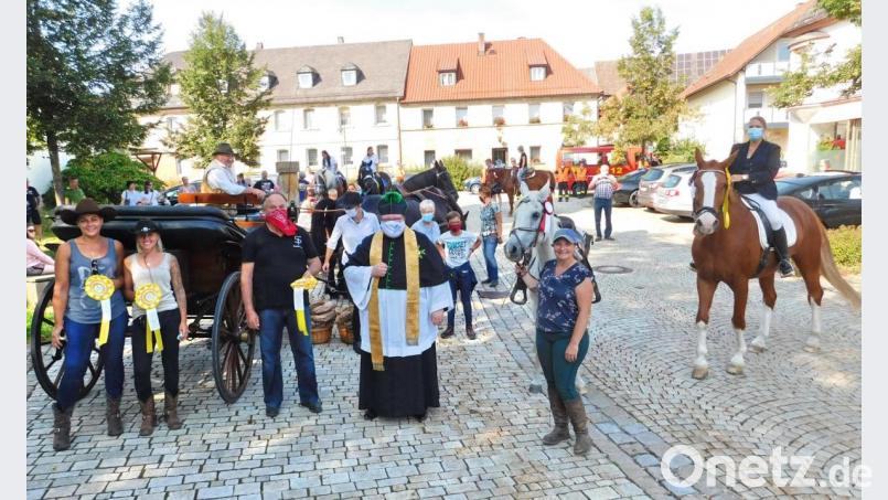 Mit Erinnerungsschleifen bedankte sich Pfarrer Sven Grillmeier (Mitte) bei den Pferdefreunden, die seit zehn beziehungsweise fünf Jahren an der Pferdewallfahrt teilnehmen. Bild: hai