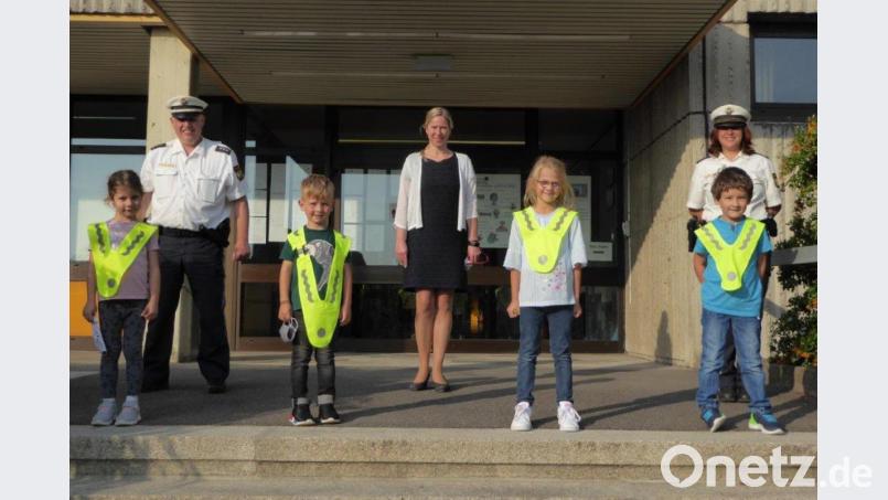 Die Erstklässler im Landkreis werden so wie die Abc-Schützen an der Grundschule Windischeschenbach mit &quot;Warn-Überwürfen&quot; ausgestatet. Tobias Wirth und Nicole Wettinger von der Polizeiinspektion Neustadt sowie Rektorin Annette Spreitzer zeigen zusammen mit einigen Schülern aus den ersten Klassen, wie gut das aussieht. Bild: Rauch/exb
