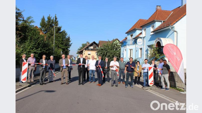 Das Band ist durchschnitten: Landrat Thomas Ebeling und Bürgermeister Martin Birner (Mitte vorne) geben, zusammen mit zahlreichen Gästen, die sanierte Diendorfer Straße offiziell wieder für den Verkehr frei Bild: pko