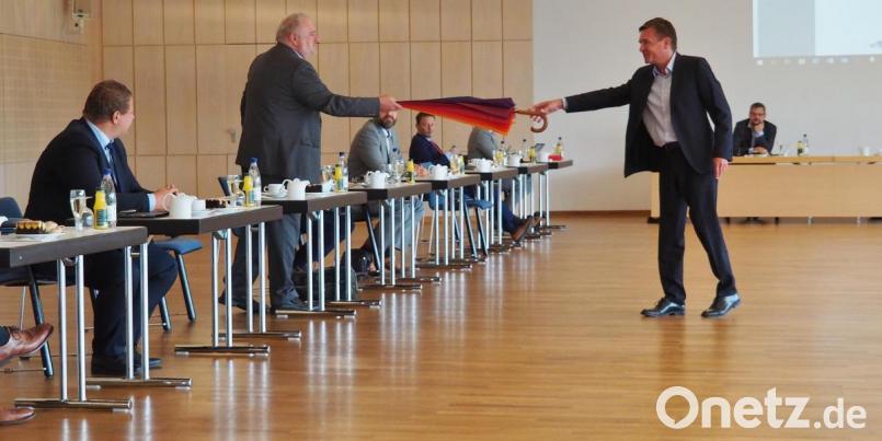 Den Eures-Schirm als Abschiedsgeschenk überreicht Arbeitsagenturchef Thomas Würdinger an Helmut Fiedler, den ehemaligen alternierenden Vorsitzenden. Bild: Bühner