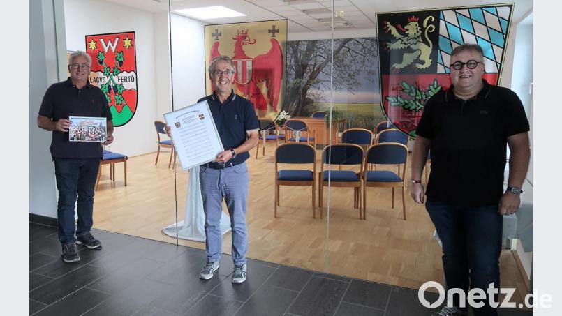 Sozialdezernent Wolfgang Hohlmeier (rechts) freut sich im Rathaus von Weiden am See über den &quot;Partnerschaftsmarsch&quot;, den die Dorfmusikanten unter Leitung von Kurt Fuhrmann eingespielt und auf CD gebannt haben. Links Bürgermeister Willy Schwartz, daneben Oberamtsrat Erwin Reger mit Cover-Bild und Notenmaterial. Bild: Kunz