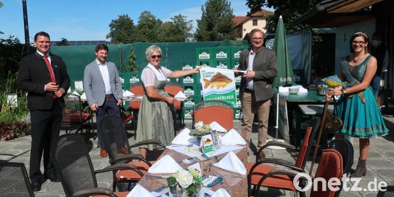 TEGO-Vorsitzender Alexander Flierl (Zweiter von rechts) überreichte Küchenchefin Erika Weiherer das Werbeplakat für den Oberpfälzer Karpfen, das alle teilnehmenden Gastronomen erhalten. Die Aktion unterstützen auch Landrat Thomas Ebeling, Bürgermeister Peter Neumeier und die Oberpfälzer Teichnixe Sophia Bächer (von links). Bild: Hirsch