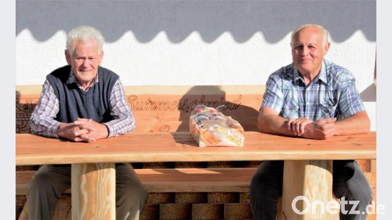 Josef Ach (links) mit Vorsitzendem Alois Hubmann vom Fotoclub auf der neuen &quot;Summerschmied-Bank&quot;, in die auch das Wappen der Stadt Pleystein eingebrannt ist, bei der Gratulationscour. Bild: tu