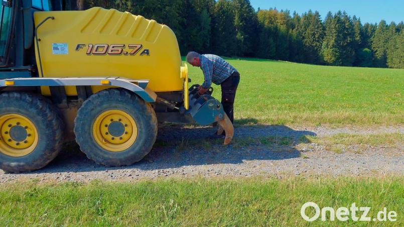 Den steinigen Untergrund der Verbindungsstraße von Frauenreuth nach Altenreuth bearbeitet Egid Schreyer mit dem Heckaufreißer seines Graders. Bild: bsc