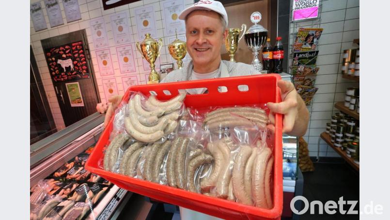 Matthias Freund hält im Verkaufsraum seiner Metzgerei eine Auswahl seiner verschiedenen Bratwürste. Bild: Karl-Josef Hildenbrand