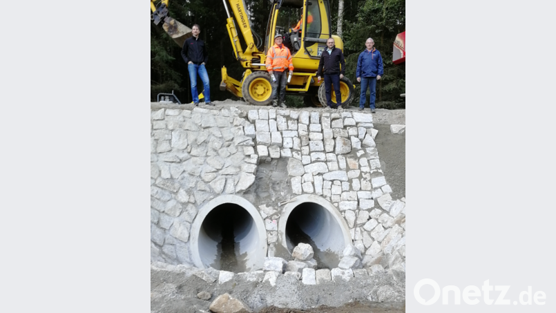 Bauamtsleiter Christian Meier, Vorarbeiter Jean Pierre Heinrichs von der Baufirma, Bürgermeister Markus Bauriedl und Dietmar Hammerl (von links) verdeutlichen mit ihrer Position oben auf der Straßenkante den erheblichen Umfang der Schadenbeseitigung. Bild: fjo