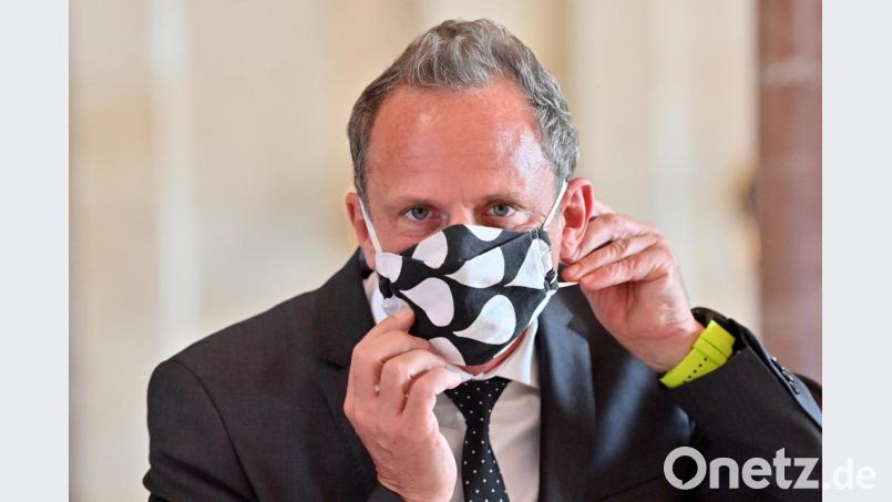 Thorsten Glauber (Freie Wähler) nimmt sich zu Beginn einer Kabinettssitzung seinen Mund-Nasen-Schutz ab. Bild: Peter Kneffel/dpa