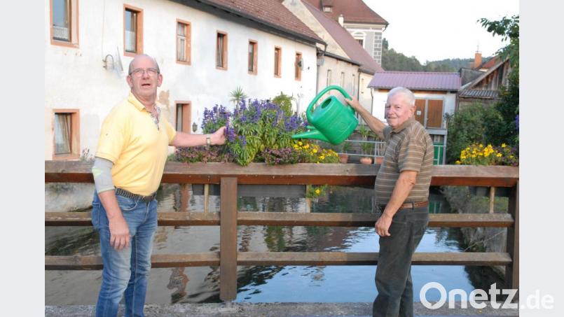 Karl Scheuerer rechts im Bild pflegt wie viele andere Blumenpaten den Blumenschmuck, hier an der Hammerbrücke. 2. Vorsitzender des Gartenbauvereins Bernhard Tischler weiß dies Engagement zu schätzen. Bild: pop