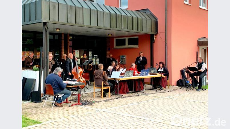 Die &quot;Waidhauser Stubenmusik&quot; bietet unter Leitung von Bernhard Kreuzer (rechts) einen famosen Auftritt unter dem Vordach des Schulgebäudes. Bild: fjo