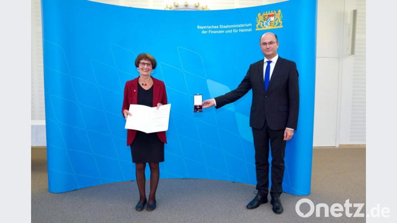 Die Weidenerin Waltraud Koller-Girke erhält von Minister Albert Füracker die Urkunde des Bundespräsidenten sowie das Bundesverdienstkreuz am Bande. Bild: Bayerisches Staatsministerium der Finanzen und für Heimat