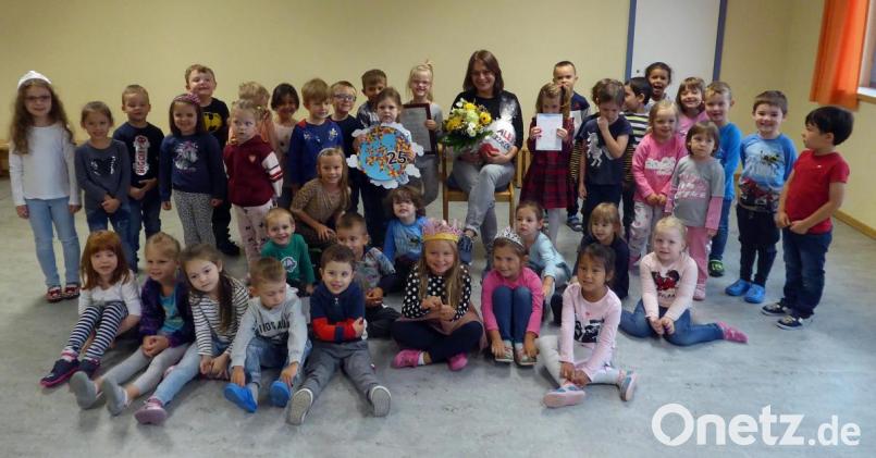 Kinderpflegerin (Mitte, sitzend) feiert inmitten der Kinder ihr 25-jähriges Dienstjubiläum. Bild: R. Kreuzer