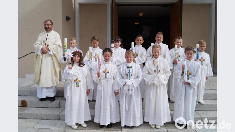 Pfarrer Thomas Stohldreier freut sich nach dem Gottesdienst mit den zwölf Schirmitzer Erstkommunikanten. Bild: du