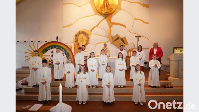 Die 13 Erstkommunionkinder mit Pfarrer Norbert Götz, Ministranten und Grundschul-Rektorin Carina Hartwig. Bild: fvo