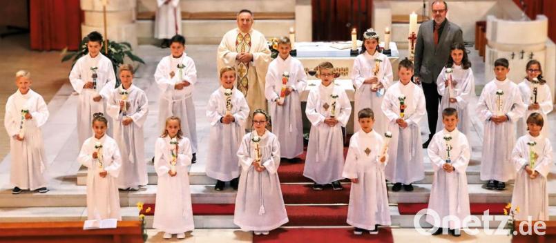 18 Kinder aus der Pfarrei Aschach-Raigering feiern ihre Erstkommunion mit Pfarrer Eduard Kroher und Gemeindereferenten Toni Rauch. Bild: sche