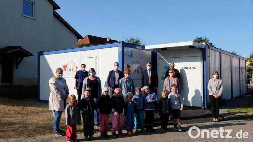 Erzieherin Theresa Ernstberger, Geschäftsleiter Harald Kergl, Erzieherin Franziska Auer, BRK-Kreisgeschäftsführer Sebastian Schaller, Kindergartenleiterin Agnes Strobl, Bürgermeister Hans-Martin Schertl, Anja Hopf vom BRK, Bauamtsleiter Stefan Ertl und Olga Keil vom Kreisjugendamt (von links) besichtigten zusammen mit einigen Kindern die Containerlösung. Bild: Stefanie Gradl