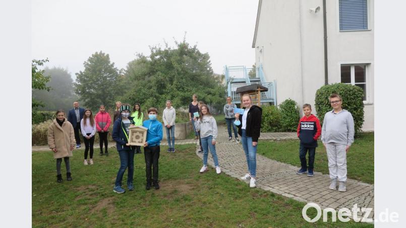 Konrektor Holger König (hinten links) freute sich mit den Lehrkräften Simone Lindner, Mariam Schraml und Silke Hertel (hinten von rechts) und den am Projekt beteiligten Schülerinnen und Schülern über das Insektenhotel. Bild: jzk