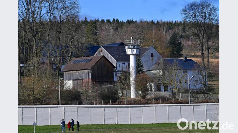 Die Mauer und ein Wachturm stehen mitten im Dorf Mödlareuth. Bild: Martin Schutt