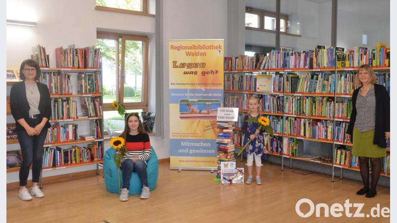 Die Gewinnerin des Leseclub-Wettbewerbs Luisa-Marie Erl (sitzend) freut sich über einen Sitzsack. Daneben die Gewinnerin des Fotowettbewerbs Leonie Kostka. Links sind Theresa Fischer und rechts Ruth Neumann, die beiden Mitarbeiterinnen der Kinderbibliothek. Bild: Kunz