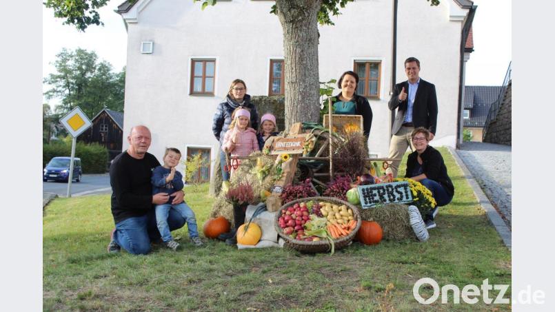 Bild zeigt die freiwilligen Helfer, die den Aufgang zur Kirche durch verschiedene Symbole zum Erntedankfest verschönert haben. Bürgermeister Wolfgang Söllner (rechts) bedankte sich im Namen der Gemeinde für die Ausführung der Arbeiten. Bild: soj