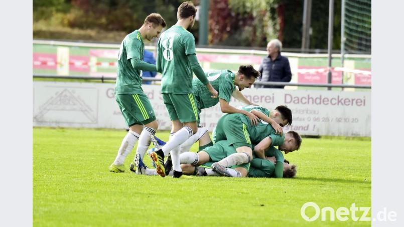 Die Spieler der DJK Ammerthal erdrücken ihren zweifachen Torschützen Jonas Weigert (unten) fast vor Freude. Bild: Hubert Ziegler