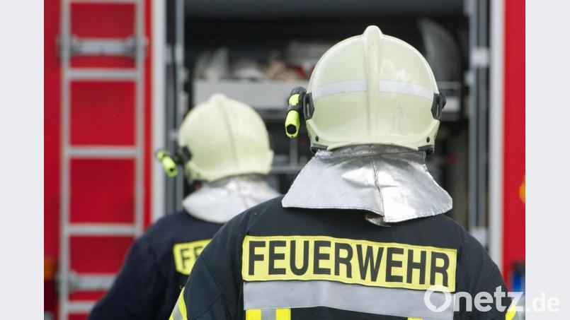 Einsatzkräfte der Feuerwehr stehen vor einem Feuerwehrauto. Bild: Stefan Sauer/dpa