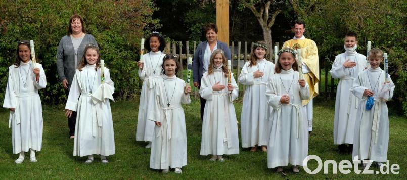 Die neun Kommunionkinder aus Neunkirchen im Pfarrgarten mit Pfarrer Thomas Kohlhepp sowie Anja Fröhlich und Verena Tafelmeier, die sich als Katechtinnen in der Vorbereitung engagierten (hinten, stehend von rechts). Bild: R. Kreuzer