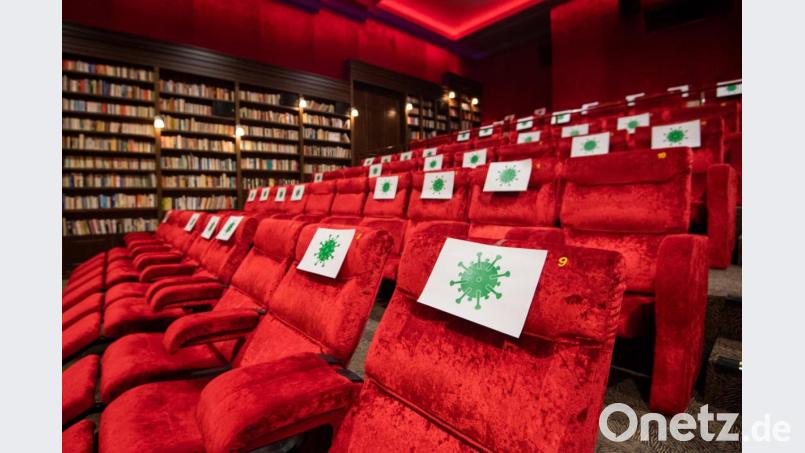 Einzelne Sitzplätze in einem Kinosaal sind mit Zetteln mit aufgedrucktem angedeuteten Virus-Symbol abgesperrt, damit Kino-Besucher einen Abstand von 1,5 Meter zueinander einhalten können. Bild: Julian Stratenschulte
